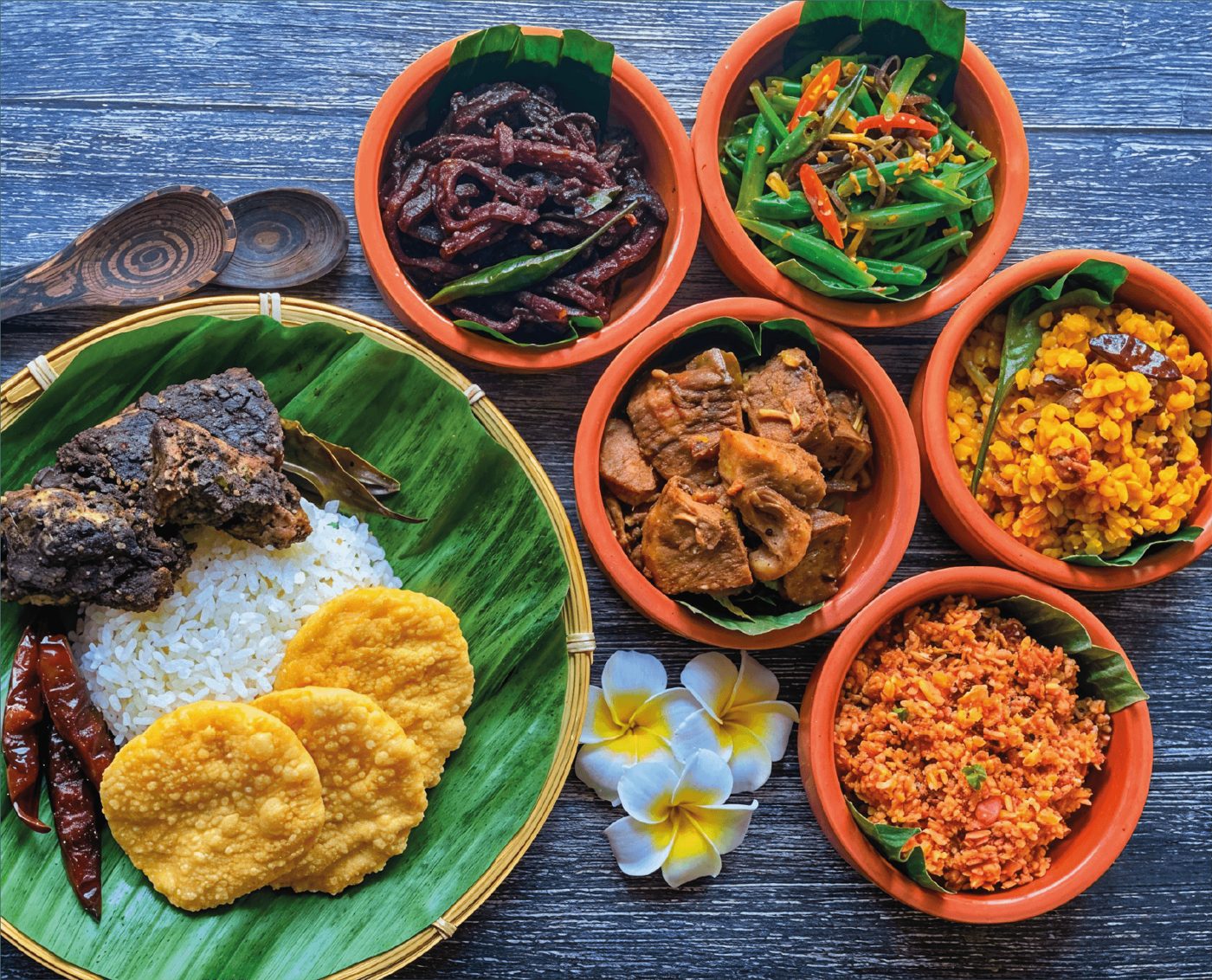 Rice and curry servito su foglia di banano con ciotole di curry, dhal, sambol e papadam